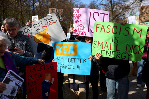 Demonstran memegang sejumlah poster "Democrats Abroad" menyerukan kepada sesama warga Amerika yang tinggal di Jerman untuk memprotes "mengakhiri kekacauan" di dalam negeri dan terhadap Presiden AS Donald Trump dan penasihatnya Elon Musk di Berlin. Foto: REUTERS/Christian Mang