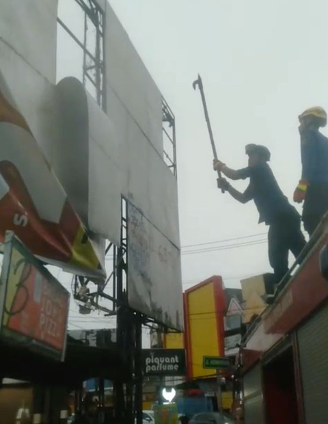 Petugas Damkar Depok memperbaiki papan reklame yang rusak di Depok. Dok. Tangkapan Layar Video