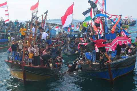Warga berebut sesaji saat mengikuti prosesi Pesta Lomban di perairan Pelabuhan Kartini, Jepara, Jawa Tengah, Senin (7/4/2025). Foto: Yusuf Nugroho/ANTARA FOTO