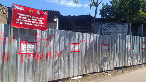 Plang dan stiker klaim gugatan lahan di kawasan Sukahaji, Babakan Ciparay, Kota Bandung, Selasa (8/4). Foto: Robby Bouceu/kumparan