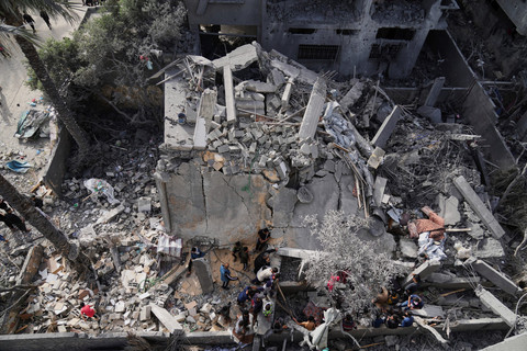 Warga Palestina memeriksa lokasi yang terkena serangan Israel di Deir al-Balah, Jalur Gaza, Senin (7/4/2025). Foto: Abdel Kareem Hana/AP PHOTO