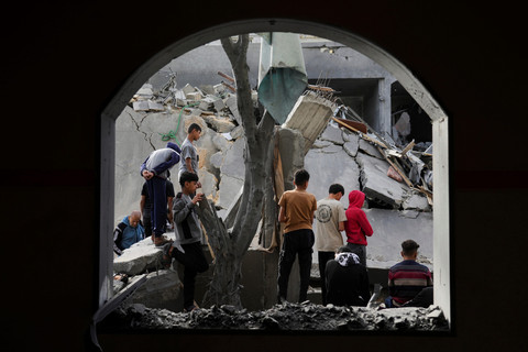 Warga Palestina memeriksa lokasi yang terkena serangan Israel di Deir al-Balah, Jalur Gaza, Senin (7/4/2025). Foto: Abdel Kareem Hana/AP PHOTO