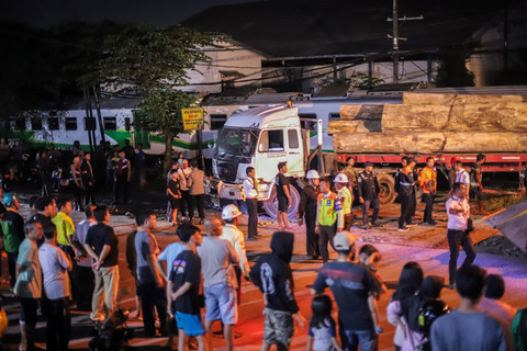 Sejumlah petugas mengevakuasi truk bermuatan kayu yang tertabrak kereta api commuter line Jenggala di Desa Tenggulunan, Kebomas, Gresik, Jawa Timur, Selasa (8/4/2025). Foto: Rizal Hanafi/ANTARA FOTO