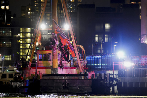 Petugas dengan dibantu menggunakan alat berat melakukan proses evakuasi bangkai helikopter di Sungai Hudson, New York, Amerika Serikat, Kamis (10/4/2025). Foto: Eduardo Munoz/Reuters