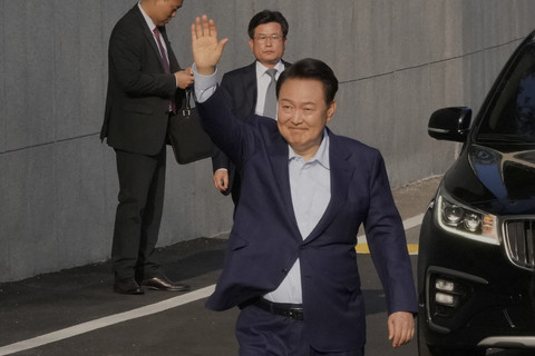 Mantan Presiden Korea Selatan Yoon Suk-yeol melambaikan tangan saat berjalan keluar rumah dinas di Seoul, Korea Selatan, Jumat (11/4/2025). Foto: AHN YOUNG-JOON/Pool/AFP