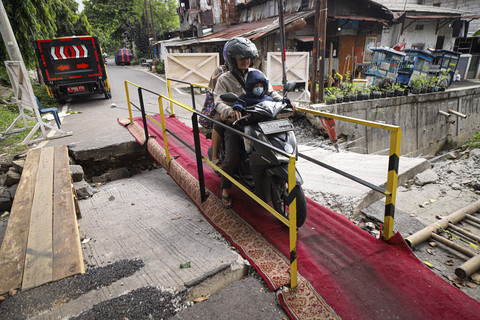 Warga melintas menggunakan sepeda motor di jembatan sementara di kawasan Kebon Manggis, Matraman, Jakarta, Sabtu (12/4/2025). Foto: Iqbal Firdaus/kumparan