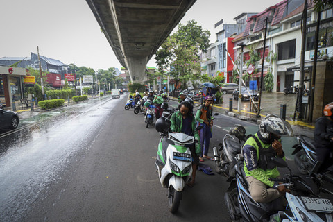 Sejumlah pengendara sepeda motor berteduh dibawah Flyover di kawasan Woltermonginsidi, Jakarta, Sabtu (12/4/2025). Foto: Iqbal Firdaus/kumparan