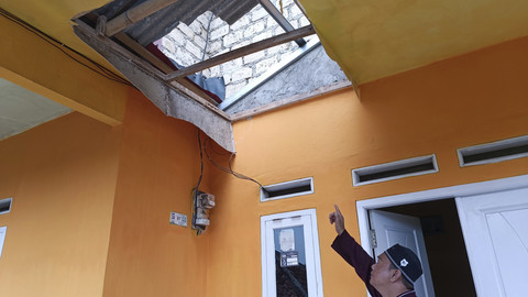 Heri (37), warga Kampung Buntar menunjukkan plafon teras rumahnya yang jebol karena gempa 4,1 m Kota Bogor, Sabtu (12/4/2025). Foto: Thomas Bosco/kumparan
