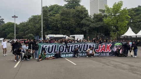 Sejumlah suporter Persebaya Surabaya, Bonek berpose dengan membentangkan spanduk sebelum menyaksikan laga Persija melawan Persebaya pada pertandingan BRI Liga 1 di Stadion Utama Gelora Bung Karno, Jakarta, Sabtu (12/4/2025). Foto: Azrumi El Ghazali/kumparan