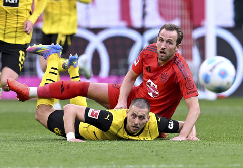 Pemain Bayern Muenchen, Thomas Muller, beraksi dengan pemain Borussia Dortmund, Salih Ozcan pada pertandingan Liga Jerman antara Bayern Muenchen vs Borussia Dortmund di Allianz Arena, Munich, Jerman, Sabtu (12/4/2025) malam WIB. Foto: Angelika Warmuth/REUTERS 
