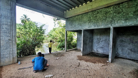 Anak-anak yang sengaja mencari ikan di bekas area pembangunan Pasar Cinde Palembang yang mangkrak, Minggu (13/4) Foto: abp/urban id