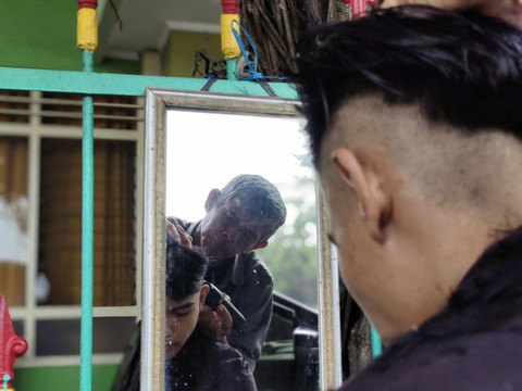 Udin tukang cukur rambut di Alun-alun Utara Yogyakarta, Rabu (16/4/2025). Foto: Arfiansyah Panji Purnandaru/kumparan