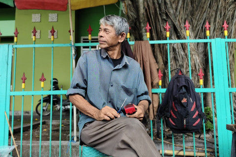 Udin tukang cukur rambut di Alun-alun Utara Yogyakarta, Rabu (16/4/2025). Foto: Arfiansyah Panji Purnandaru/kumparan