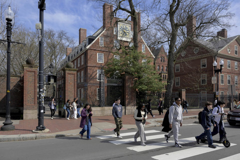 Para mahasiswa berjalan di luar Harvard Yard di Universitas Harvard di Cambridge, Massachusetts, AS, Selasa (15/4/2025). Foto: Faith Ninivaggi/REUTERS
