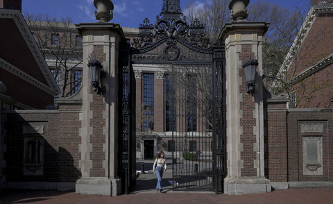Seorang wanita berjalan di kampus Universitas Harvard di Cambridge, Massachusetts, AS, Selasa (15/4/2025). Foto: Faith Ninivaggi/REUTERS