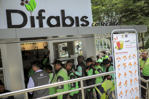Masyarakat dan pengemudi ojek online antre saat pembagian kopi gratis dari Difabis Coffee di kawasan Terowongan Kendal, Jakarta, Rabu (16/4/2025). Foto: Jamal Ramadhan/kumparan