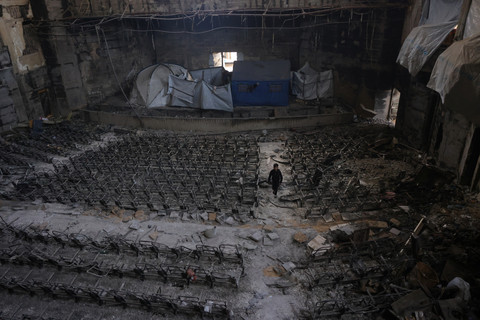 Anak yang mengungsi berjalan di dalam auditorium kampus Universitas Islam yang rusak di Kota Gaza, Rabu (16/4/2025). Foto: Bashar Taleb/AFP