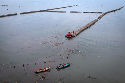Pekerja menggunakan alat berat saat membongkar pagar laut di pesisir laut Desa Kohod, Kabupaten Tangerang, Banten, Kamis (17/4/2025). Foto: ANTARA FOTO/Putra M. Akbar