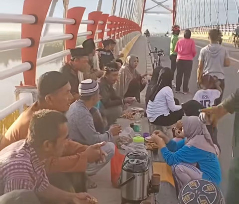 Warga Desa Sungai Besar gelar syukuran dengan makan ketupat di Jembatan  Sambas Sungai Besar (JSSB). Foto: Dok. instagram @beritesambas