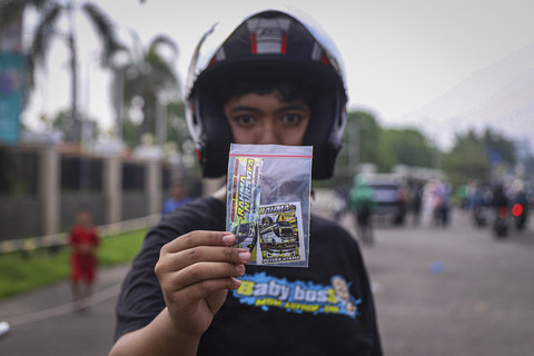 Sejumlah warga berkumpul dan merekam bus dengan klakson 'Telolet' di kawasan Cipinang, Jakarta, Jumat (18/4/2025). Foto: Iqbal Firdaus/kumparan