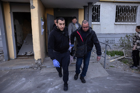 Warga mengeluarkan jenazah seorang pria yang tewas setelah serangan rudal Rusia di kawasan permukiman, di tengah serangan Rusia terhadap Ukraina, di Kharkiv, Ukraina, 18 April 2025. Foto: REUTERS/Marko Djurica
