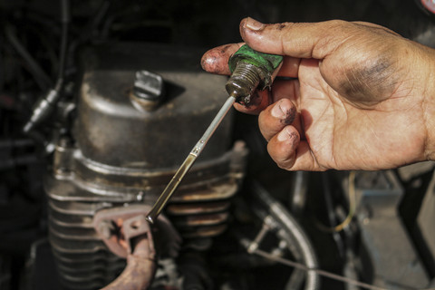 Memeriksa oli: Ekawati mengecek oli Bajaj. Foto: Idlan Dziqri Mahmudi/ANTARA FOTO