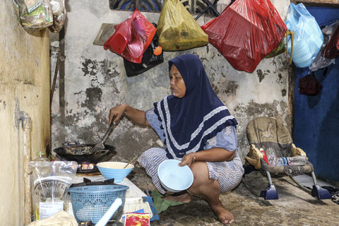 Masak: Ekawati memasak di rumah kontrakan. Foto: Idlan Dziqri Mahmudi/ANTARA FOTO