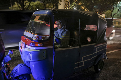 Hingga malam hari: Ekawati mengendarai bajaj untuk mencari penumpang hingga malam hari. Foto: Idlan Dziqri Mahmudi/ANTARA FOTO