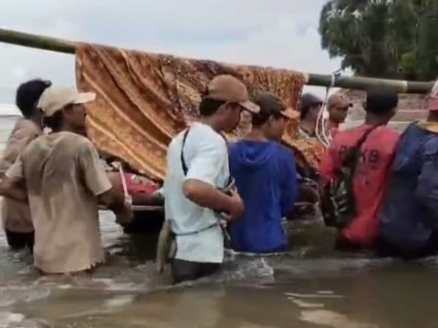 W arga Pekon Bandar Dalam, Kecamatan Bengkunat, Kabupaten Pesisir Barat bergotong royong menandu Kepala Desa (Peratin), yang sedang sakit menuju fasilitas kesehatan | Foto : Tangkap layar video