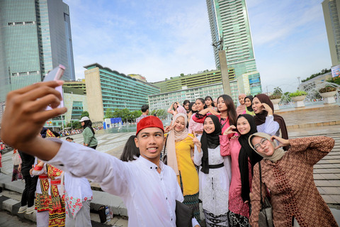 Perempuan yang mengenakan kebaya swafoto saat memperingati Hari Kartini di car free day (CFD) Kawasan Bundaran HI, Jakarta, pada Minggu (20/4/2025). Foto: Jamal Ramadhan/kumparan
