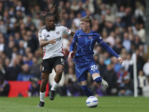Pemain Chelsea, Cole Palmer, beraksi dengan pemain Fulham, Alex Iwobi pada pertandingan Liga Inggris antara Fulham vs Chelsea di Craven Cottage, London, Inggris, Minggu (20/4/2025). Foto: Paul Childs/REUTERS