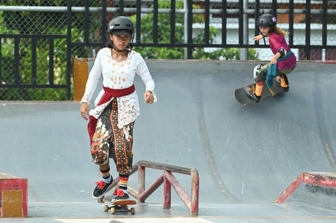 Dua anak bermain skateboard dengan mengenakan busana kebaya di Denpasar, Bali, Minggu (20/4/2025). Foto: Fikri Yusuf/ANTARA FOTO