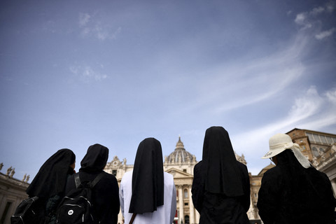 Para biarawati berdiri di Lapangan Santo Petrus, setelah kematian Paus Fransiskus diumumkan oleh Vatikan dalam sebuah pernyataan video, di Vatikan, Senin (21/4/2025). Foto: Yara Nardi/REUTERS
