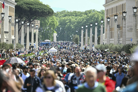 Umat beriman dan peziarah berjalan di jalan Della Conciliazione saat mereka tiba untuk berkumpul di alun-alun Santo Petrus setelah wafatnya Paus Fransiskus di Vatikan, Senin (21/4/2025). Foto: Alberto Pizzoli/AFP