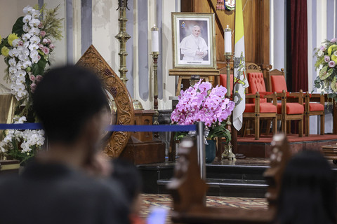 Umat Katolik berdoa di dekat foto Paus Fransiskus sebelum mengikuti misa harian di Gereja Katedral, Jakarta, Senin (21/4/2025). Foto: Dhemas Reviyanto/ANTARA FOTO