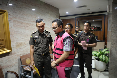 Advokat Junaidi Saibih (kanan) dikawal petugas menuju mobil tahanan usai menjalani pemeriksaan di Gedung Kejaksaan Agung, Jakarta, Selasa (22/4/2025). Foto: Kejagung