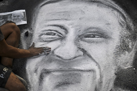 Seniman Argentina Javier Sativa menggambar wajah mendiang Paus Fransiskus di jalan di depan pintu masuk Katedral Buenos Aires, Argentina, Senin (21/4/2025) waktu setempat. Foto: Luis Robayo/AFP