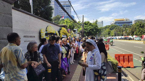 Suasana di depan Kedubes Vatikan, Jakarta Pusat, pada Rabu (23/4/2025). Warga mengantre dan ada karangan bunga. Foto: Rachmadi Rasyad/kumparan