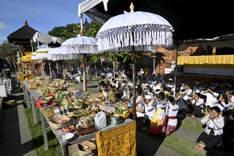 Umat Hindu menyiapkan sesajen saat persembahyangan Hari Raya Galungan di Pura Jagatnatha, Denpasar, Bali, Rabu (23/4/2025). Foto: Sonny Tumbelaka/AFP
