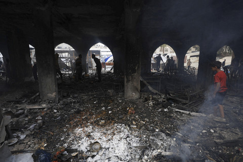 Sejumlah warga melihat bangunan yang hangus terbakar akibat serangan Israel di salah satu sekolah yang dijadikan penampungan di Gaza, Rabu (23/4/2025). Foto: Dawoud Abu Alkas/REUTERS