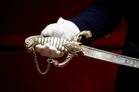 Seorang karyawan Drouot memegang pedang miliki Napoleon yang dibuat oleh arquebusier Nicolas-Noel Boutet pada tahun 1802 sebelum dilelang di rumah lelang Drouot di Paris, Prancis, 24 April 2025. Foto: REUTERS/Benoit Tessier