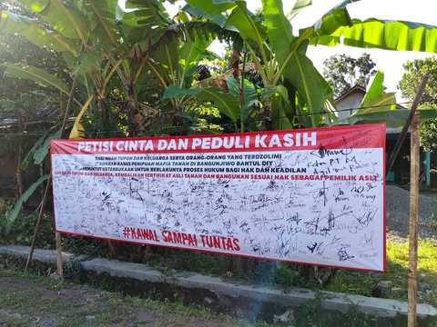 Spanduk dan tanda tangan dukungan warga RT 04 Dusun Ngentak, Kaluragan Bangunjiwo, Kapanewon Kasihan, Kabupaten Bantul, kepada Mbah Tupon korban mafia tanah. Foto: Arfiansyah Panji Purnandaru/kumparan