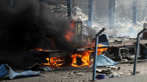 Api melalap sebuah truk di sepanjang jalan raya yang hancur menyusul ledakan di dermaga pelabuhan Shahid Rajaee, Iran. Foto: MOHAMMAD RASOLE MORADI / IRNA / AFP