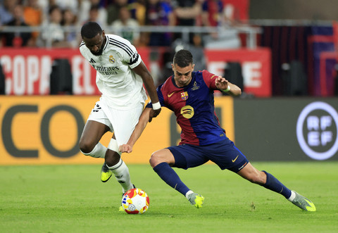 Antonio Rudiger dari Real Madrid beraksi bersama Ferran Torres dari FC Barcelona pada pertandingan final Copa del Rey antara Barcelona vs Real Madrid di Estadio de La Cartuja, Seville, Spanyol, Minggu (27/4/2025) dini hari. Foto: Borja Suarez/REUTERS