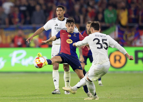 Raul Asencio dari Real Madrid beraksi bersama Pedri dari FC Barcelona pada pertandingan final Copa del Rey antara Barcelona vs Real Madrid di Estadio de La Cartuja, Seville, Spanyol, Minggu (27/4/2025) dini hari. Foto: Borja Suarez/REUTERS