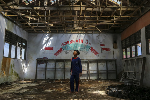 Seorang siswa melihat kondisi salah satu ruang kelas yang rusak di SMP Negeri 2 Cimanuk, Pandeglang, Banten, Senin (28/4/2025). Foto: Angga Budhiyanto/ANTARA FOTO 