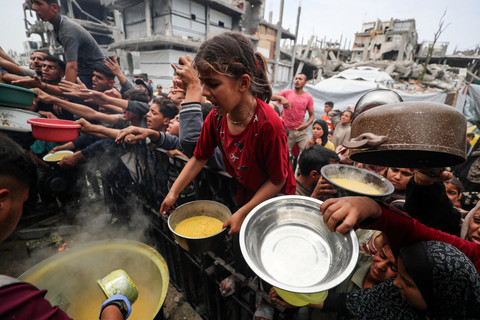 Warga Palestina berkumpul untuk menerima makanan yang dimasak oleh dapur amal di Beit Lahia, Jalur Gaza utara, Kamis (24/4/2025). Foto: Mahmoud Issa/REUTERS