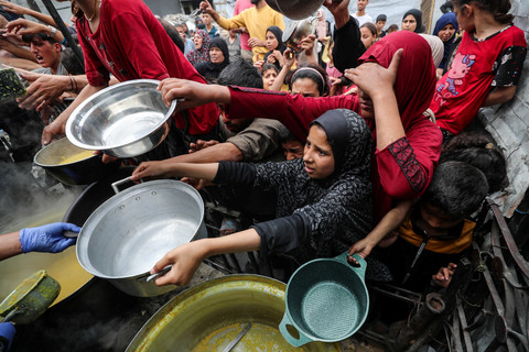 Warga Palestina berkumpul untuk menerima makanan yang dimasak oleh dapur amal di Beit Lahia, Jalur Gaza utara, Kamis (24/4/2025). Foto: Mahmoud Issa/REUTERS