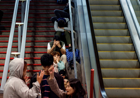 Para pelancong duduk di tangga stasiun kereta Atocha, menyusul pemadaman listrik besar-besaran di Madrid, Spanyol, Senin (28/4/2025). Foto: Oscar Del Pozo/AFP