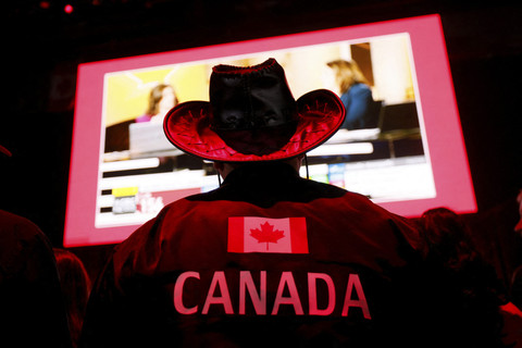 Seorang pendukung Perdana Menteri Kanada Mark Carney mengenakan jaket berhiaskan bendera Kanada di markas besar malam pemilihan Partai Liberal di Ottawa, Ontario, Kanada, Senin (28/4/2025). Foto: Blair Gable/REUTERS